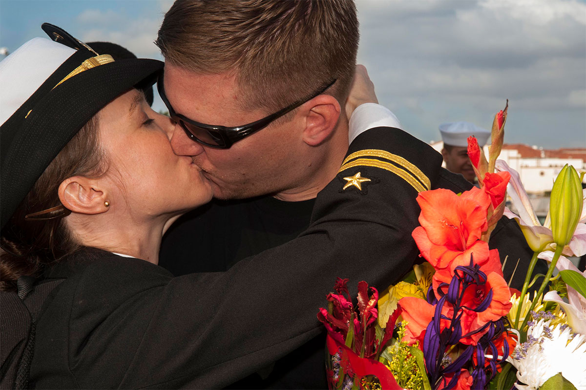Lt. Katie Jacobson greets her husband Lt. Kevin Jacobson with a kiss