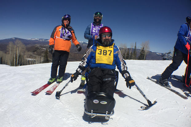 Volunteer ski instructor Alec Tossani (back row, in blue) poses with another instructor and Marine Corps veteran Patrick Ozborn as the trio tackle the slopes of Snowmass Mountain.