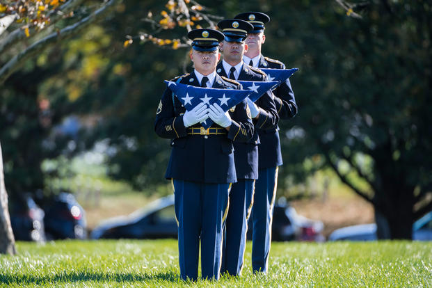 Soldiers hold folded American flags that will be presented to family members. (Elizabeth Fraser/Arlington National Cemetery)
