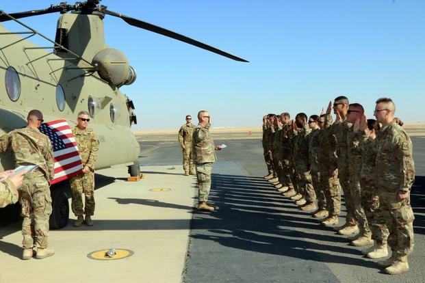 Soldiers from the Iowa Army National Guard take the oath of reenlistment at Camp Buehring, Kuwait.