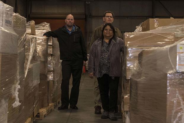 Darlene Thompson, Stephen Schultz and Joseph Gagnon, 30th Contracting Squadron civilians, pose Feb. 12, 2019, in a warehouse used for storing government property at Vandenberg Air Force Base, Calif. Their team is responsible for saving $1 billion over the course of seven years. (Airman 1st Class Hanah Abercrombie/U.S. Air Force