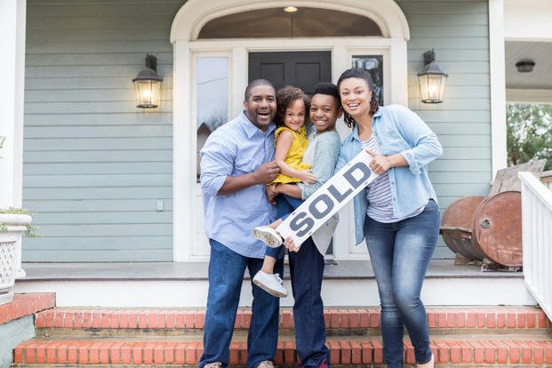 Family with "sold" house sign