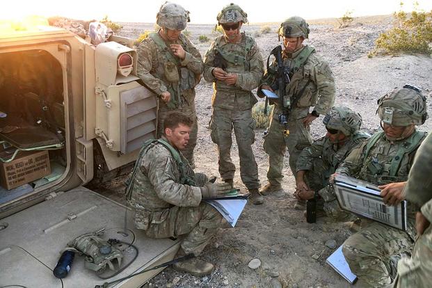 Capt. Eric Cannon, commander of Charlie Company, 2nd Battalion, 69th Armor Regiment, seated, briefs his leaders the night before the May 8, 2019, attack on the fictional town of Razish at the National Training Center at Fort Irwin, California. Matthew Cox/Military.com