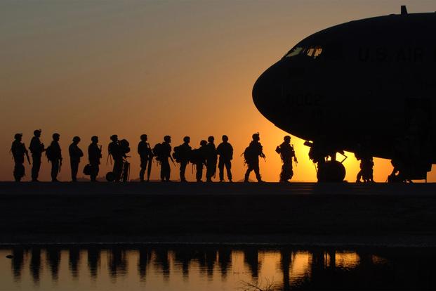 The sun sets behind a C-17 Globemaster III as soldiers wait in line to board the aircraft at Joint Base Balad, Iraq. (U.S. Air Force/Tech. Sgt. Erik Gudmundson)