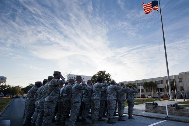 Airmen pause for retreat, also known as reveille.  (U.S. Air Force/Samuel King Jr.)