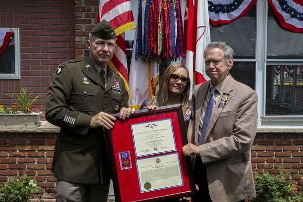 Robert Ollis, father of Staff Sgt. Michael Ollis, and Kimberly Loschiavo, the soldier's sister, posthumously receive the Distinguished Service Cross from Gen. James C. McConville, vice shief of staff of the Army, on June 8, 2019, at the Staff Sgt. Michael Ollis VFW Post on Staten Island, New York. (U.S. Army photo by Sgt. Jerod Hathaway)