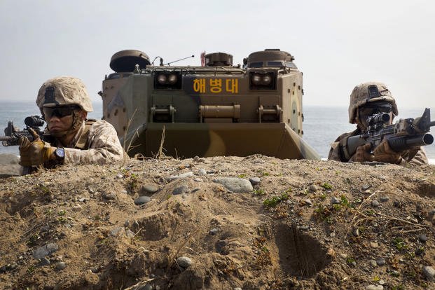Marines from 2nd Battalion, 3rd Marine Regiment, assigned to 3rd Marine Expeditionary Brigade, wait for the command to advance after rushing out of a Republic of Korea Marine amphibious assault vehicle March 31, 2014, during Ssang Yong 2014 at Dokseok-ri beach in Pohang, Republic of Korea. Ssang Yong exercise is the combined capability of ROK and U.S. Navy and Marine Corps forces. (U.S. Marine Corps photo by Lance Cpl. Cedric R. Haller II)
