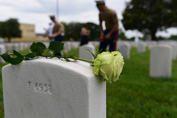 U.S. Marines place flowers on gravesites of fallen service members during a Memorial Day wreath-laying ceremony at Hampton National Cemetery in Hampton, Virginia, May 28, 2018. (U.S. Air Force photo/Monica Roybal)