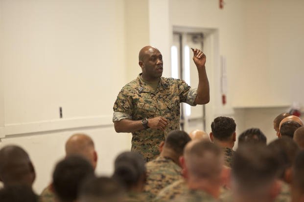 Sergeant Major of the Marine Corps Sgt. Maj. Ronald L. Green, holds up an eagle, globe and anchor while he speaks of never losing motivation to the Marines of Staff Non-Commissioned Officers Academy at Camp Johnson N.C. Sept. 7, 2017. (Tyler Pender/Marine Corps)