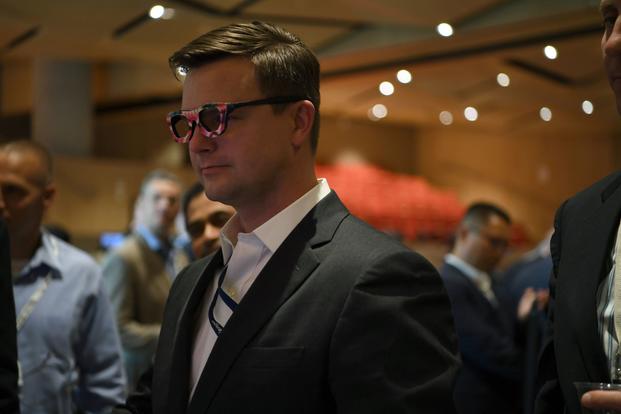 A conference attendee tries on glasses designed to thwart facial recognition software.