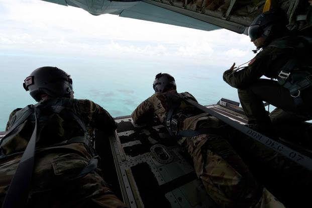 Members of the Rhode Island National Guard and Air National Guard look out from a C-130 off the Bahamas.