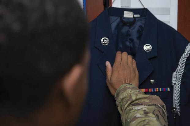 An honor guardsman reaches for his uniform at Dyess Air Force Base.