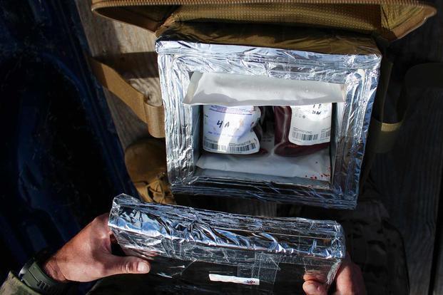 A box containing blood bags is opened.
