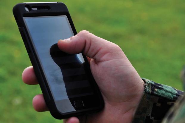 A U.S. Marine holding a cell phone. 
