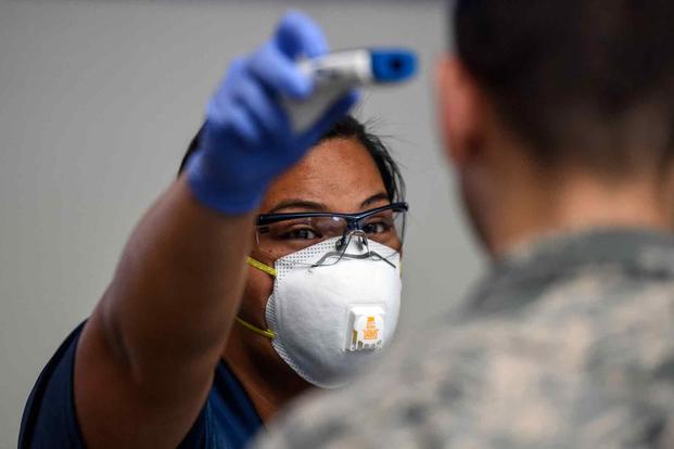 Airman tests a no-touch thermometer at Joint Base Pearl Harbor-Hickam
