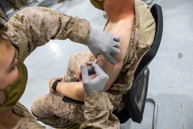 A U.S. Marine receives the COVID vaccine in Kuwait