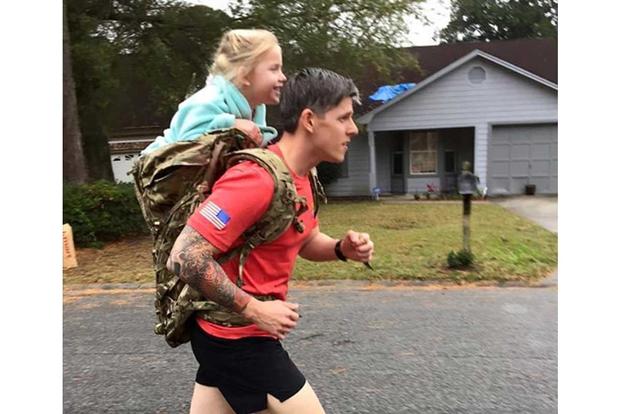 Sgt. 1st Class Christopher Celiz trains while carrying his daughter
