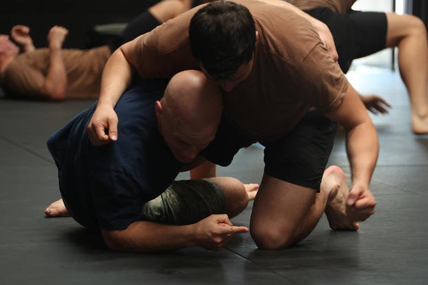 SEAL candidates grapple with instructors during a combatives course.
