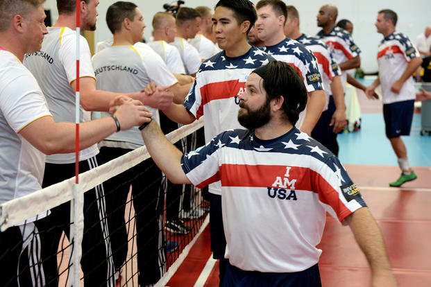 Members of the United States sitting volleyball team shake hands with members of the German team at the 2014 Invictus Games.