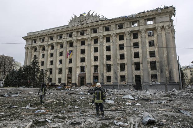 A member of the Ukrainian Emergency Service looks at City Hall in Kharkiv.
