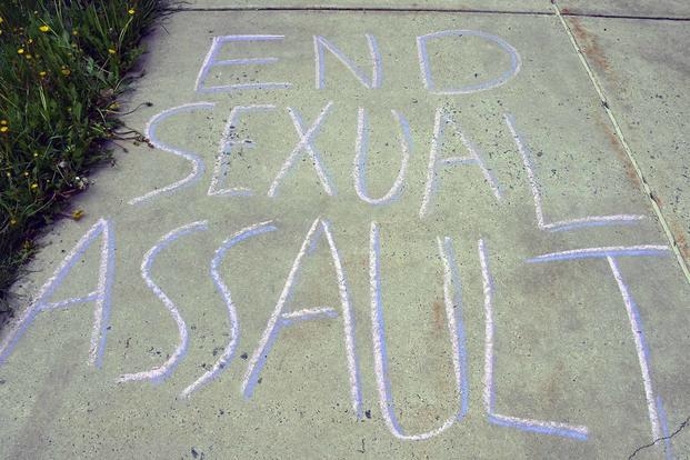 "End Sexual Assault" is written on a sidewalk.