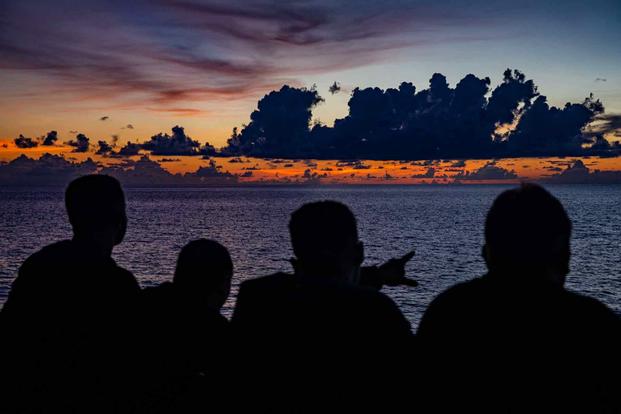 Sailors aboard USS Chancellorsville view the sunset.