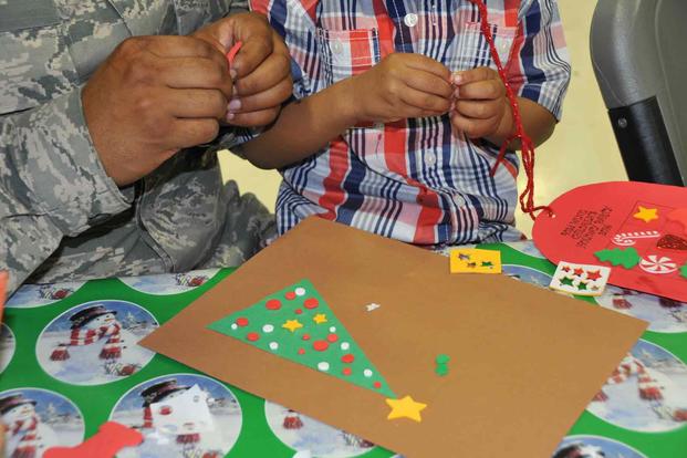 An airman and his son work together to create a Christmas card.