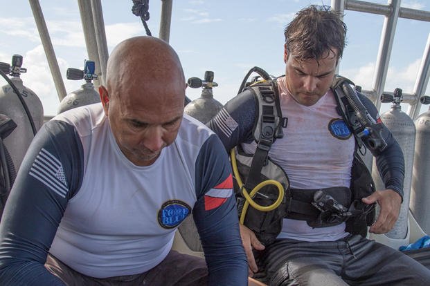 Angelo Fiore and Nate Quinn, both divers working with Force Blue, a nonprofit veterans organization, gear up before going on a mission to collect and transplant coral reef in Puerto Rico.