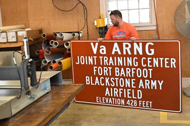 Employees make "Fort Barfoot" signs to replace existing "Fort Pickett" signs.