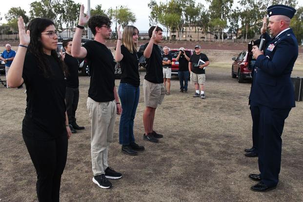 Teens outdoors raise their hands to take the Oath of Enlistment for the Space Force.
