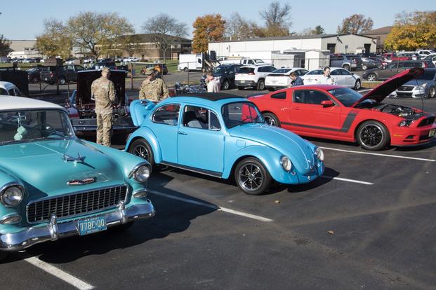 Service members show off their hobby cars in a parking lot