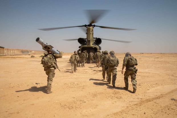 U.S. Army soldiers board a CH-47 Chinook helicopter at Al Asad Air Base, Iraq