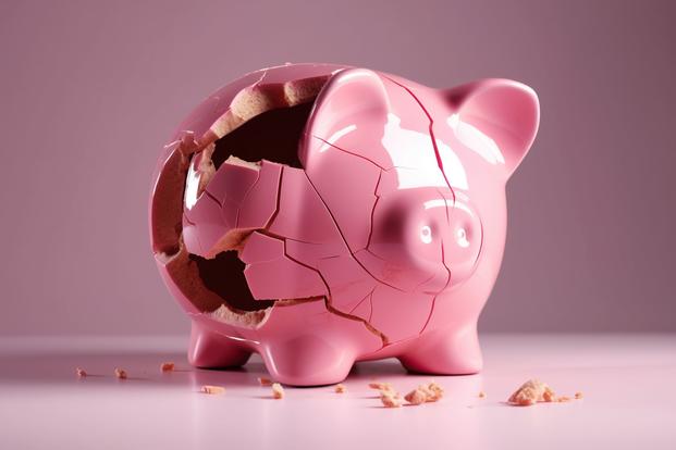 A pink piggy bank is shattered and fractured.
