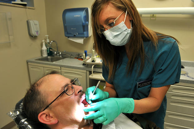 dental assistant examines patient