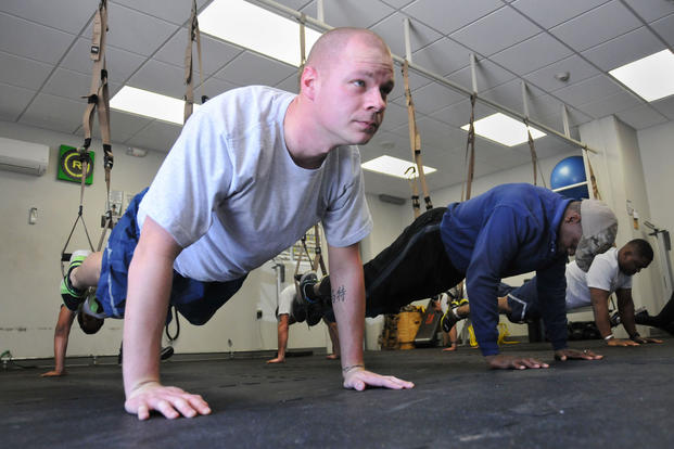 A tech sergeant performs push-ups during a TRX suspension training program at Dobbins’ Human Performance Center.