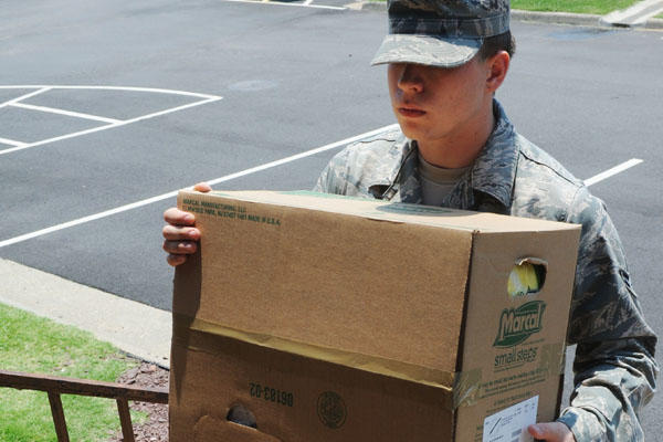 A servicemember carrying a box
