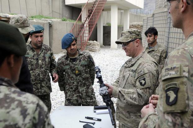 Sgt. 1st Class Chad Clark teaches Afghan National Army soldiers from 4th Combat Support Kandak, 2nd Brigade, 201st Corp, on weapons handling, March 12, 2013, at Combat Outpost Fortress, Kunar Province, Afghanistan. (Photo Credit: Sgt. Jon Heinrich)