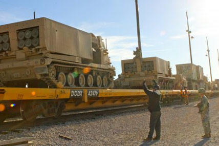 Soldiers from 2nd Battalion, 20th Field Artillery Regiment, task Force Pegasus, work to load multiple launch rocket systems onto flat train cars at the Fort Hood railhead, Jan. 30. (U.S. Army photo by Sgt. Garett Hernandez)