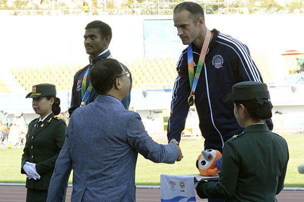 U.S. Army Sgt. Robert Brown shakes hands with Korean Track and Field Association Vice President Hwang Gu Hoon after receiving the gold medal for the 100-meter para dash at the CISM in Mungyeong, South Korea, Oct. 5, 2015. (U.S. Army/ Gary Sheftick)