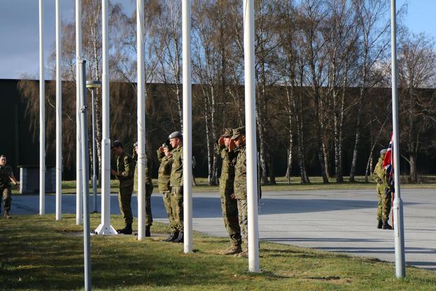 Marines and Norwegian soldiers salute their respective flags during a V-E Day ceremony at Vaernes Garrison, Norway, on May 8, 2017. Hope Hodge Seck/Military.com