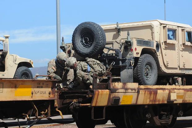 Soldiers from the 3rd Armored Brigade Combat Team, 4th Infantry Division secure a Humvee onto a rail car during the brigade's rail-load operations at the Fort Carson railhead, Aug. 9, 2016. (Army/Capt. Scott Walters.) 