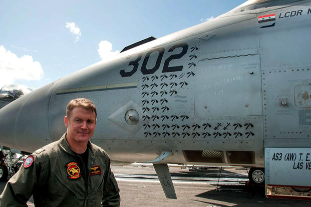 Lt. Cdr. Michael Tremel stands next to his F/A 18-E Super Hornet on board the USS George W. Bush last July. The tomahawk symbols represent strike missions and the "kill" symbol for his shootdown is upper right. (Photo courtesy of Save The Royal Navy)