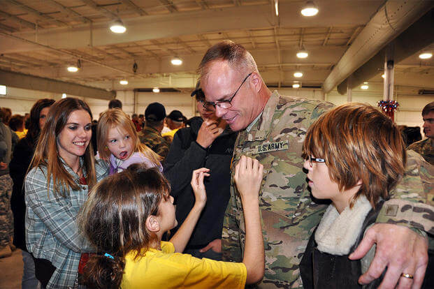 Sgt. 1st Class John Lemke, of the Wisconsin Army National Guard’s B Battery, 1st Battalion, 121st Field Artillery Regiment, greets his family after a 10-month deployment to Afghanistan. (U.S. Army Photo)