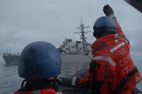 Two crewmen aboard a Coast Guard Cutter Bertholf small boat signal the crew of the USS Decatur during the Northern Edge exercise in June, 2011. (U.S. Navy photo)