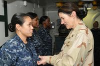 Rear Adm. Margaret Klein pins an Enlisted Surface Warfare Specialist insignia on Hospital Corpsman 1st Class Jennifer Gallardo during a visit aboard the amphibious assault ship USS Kearsarge (LHD 3). (MC3 Cristina Gabaldon/U.S. Navy)