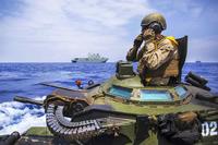 A U.S. Marine communicates with other assault amphibious vehicles.