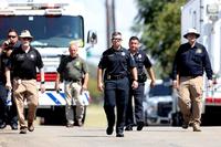 Fort Worth police officers walk in the neighborhood where a military jet crashed.