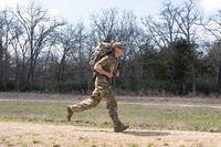 A competitor in the Texas Military Department Joint Best Warrior Competition 2021 completes the ruck march event in Bastrop, Texas.