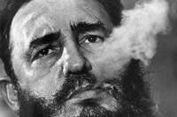 Fidel Castro exhales cigar smoke.