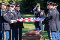 Soldiers prepare to fold the national flag during a full honors funeral at Arlington National Cemetery.